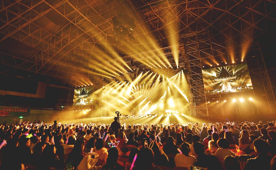 Dynamic concert scene with vibrant crowd and dazzling stage lights indoors.