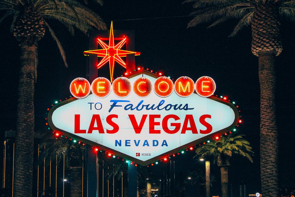 The iconic Welcome to Fabulous Las Vegas sign illuminated at night with palm trees in the background.